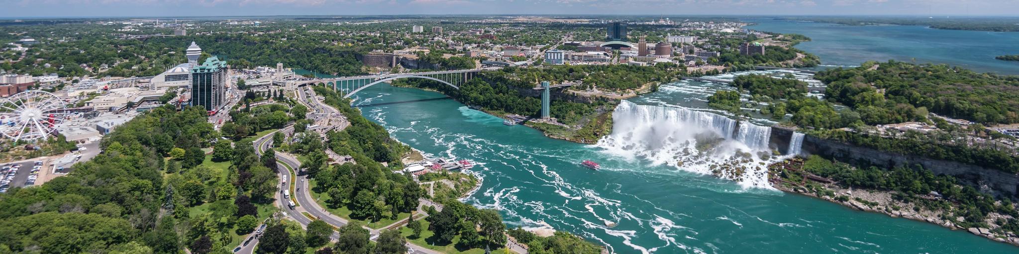 A loaded river barge under the West End bridge on the Ohio river with the  Rivers Casino and Heinz Field in the background in summer time, Pgh, PA, USA  Stock Photo 