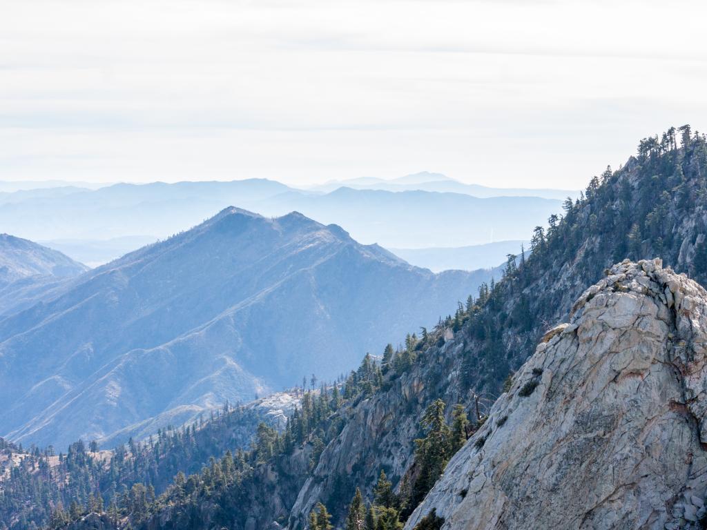 Mount San Jacinto State Park mountains stretching into the distance with a forest and blue haze.