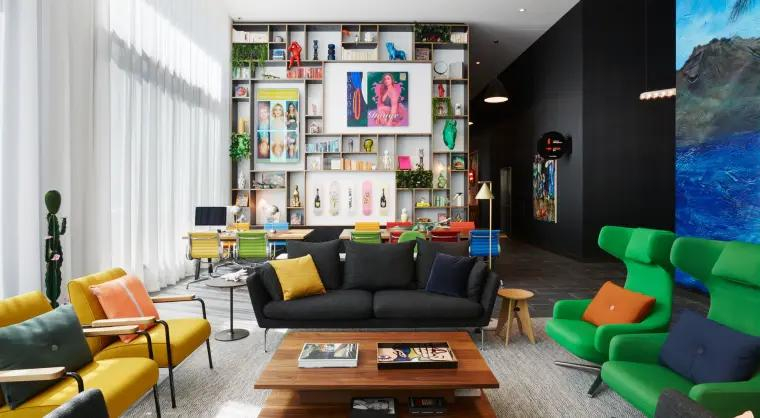 Brightly coloured lounge area, with modern art and bright seating at citizenM Los Angeles Downtown