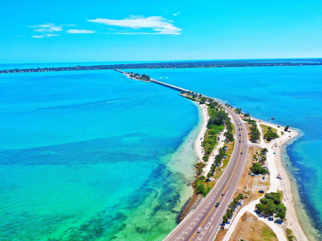 Aerial view of the road leading to Sanibel Island, FL, surrounded by turquoise waters