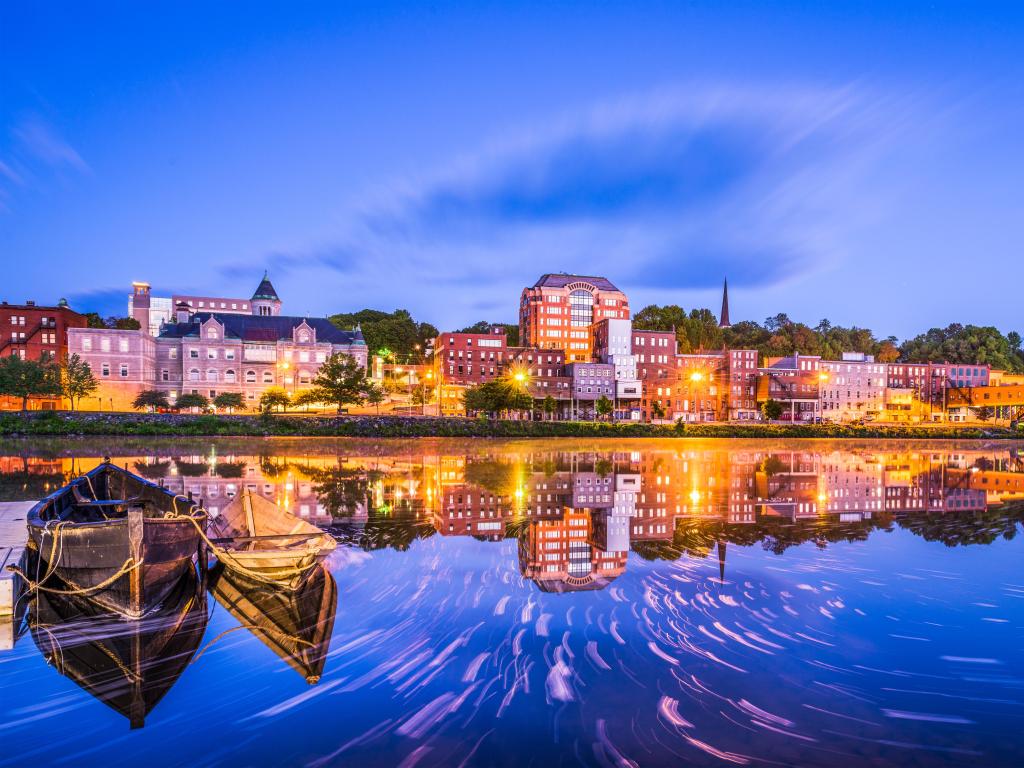 Augusta, Maine, USA downtown skyline on the Kennebec River taken at night.