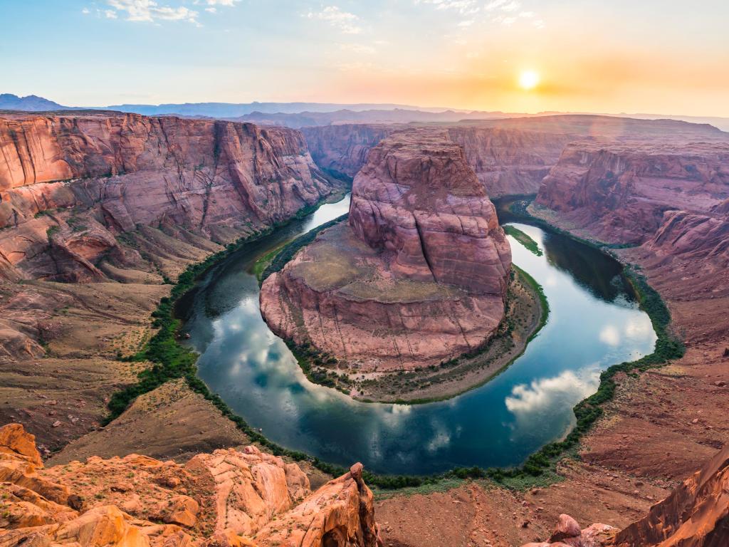 Horseshoe Bend, Grand Canyon, Arizona, USA taken at sunset with the Colorado River and red rocks in the distance.