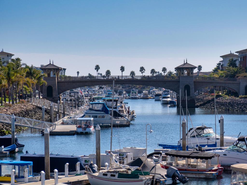 Marina in Oxnard, California, with yachts, palm trees and a bridge crossing the waterway