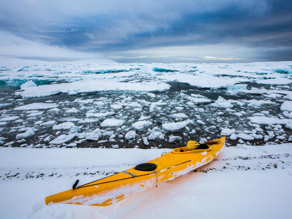 A yellow kayak in the frozen water in Nunavut, Canada
