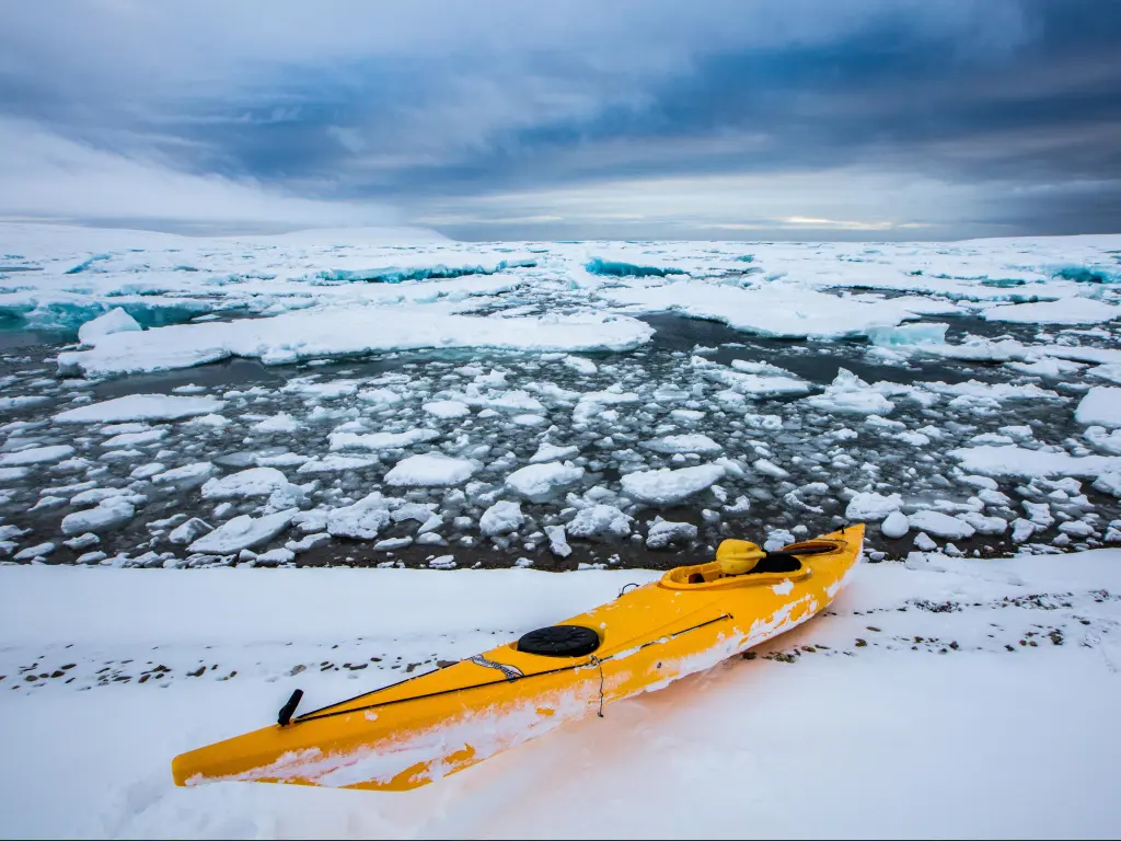 A yellow kayak in the frozen water in Nunavut, Canada