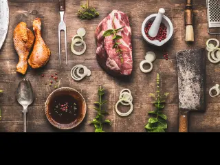 Table full of meat, spices and tools for every BBQ style