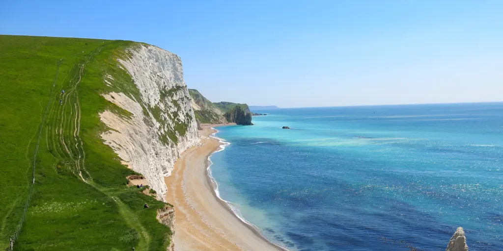 Blue water and grass-covered cliffs on the Jurassic Coast in England