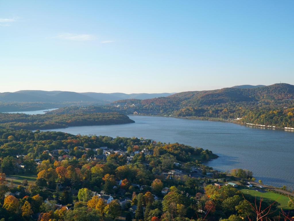 Hudson River, New York, USA with a beautiful scenic overlook view of Hudson River valley on an autumn morning, sunrise over the hills. Fall foliage on trees throughout the countryside.