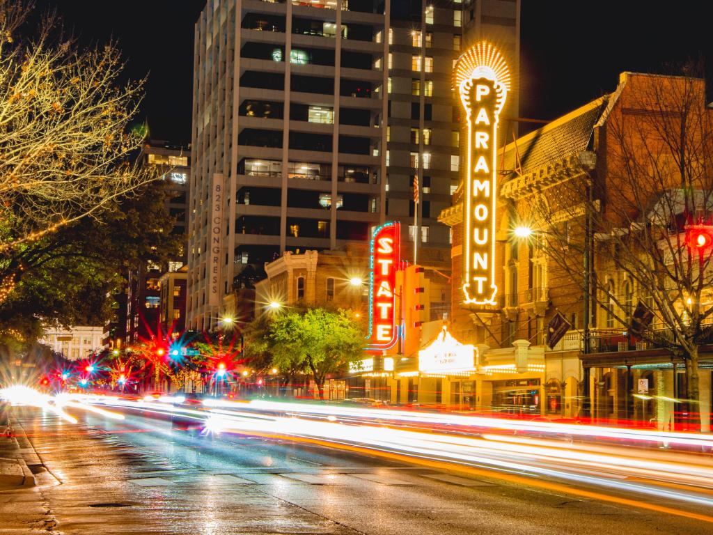 time exposure of traffic lights on congress avenue in downtown Austin in front of the Paramount and State theaters at night