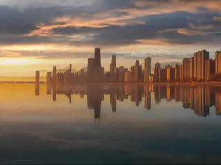High rise Chicago skyline is in the background, with Lake Michigan reflecting low sun in the foreground