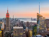 Aerial view over New York City at sunset. The Empire State Building is colored in red to honor the New York City Fire Department (FDNY).