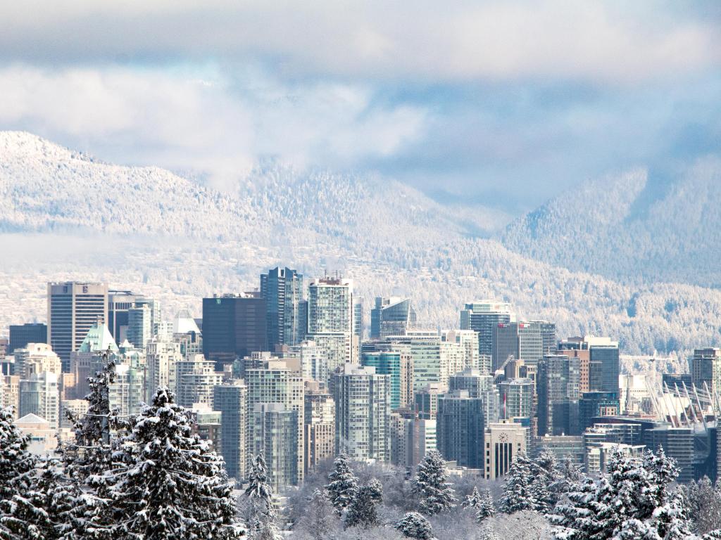 View of the Vancouver skyline in the snow with mountains behind the skyscrapers