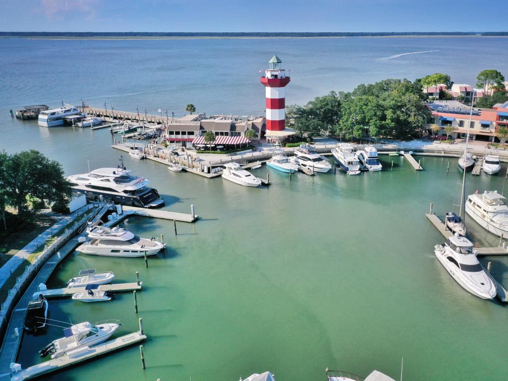 Hilton Head Island, South Carolina, USA taken at the Harbor town with an aerial view of boats moored in the marina and a lighthouse on the pier.