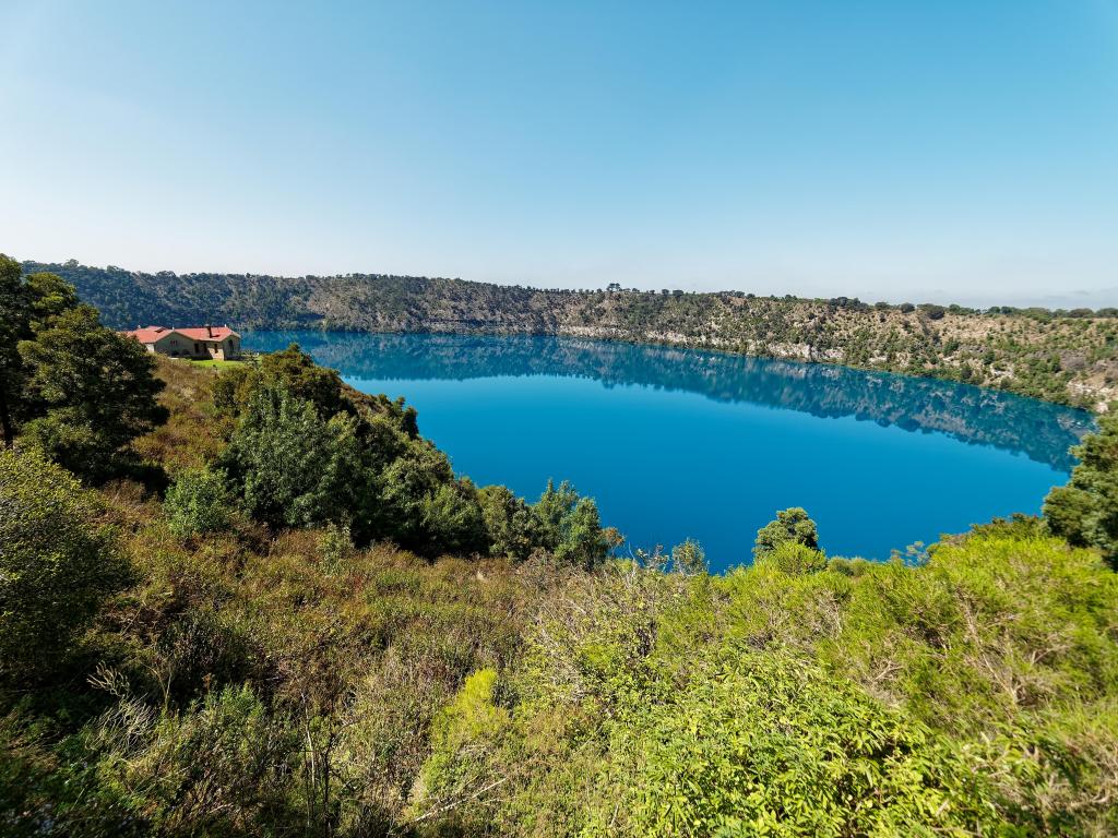 Blue Lake, Mount Gambier, South Australia with views of the amazing volcano crater Blue Lake with stunning reflection of the Crater Rim and historic pumping station for town water supply. 