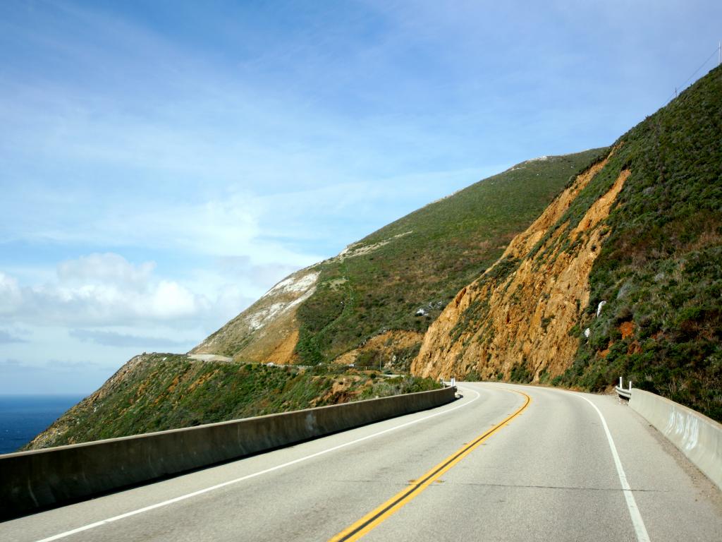 An image of the coastal highway 101, California, in a cloudy blue sky.