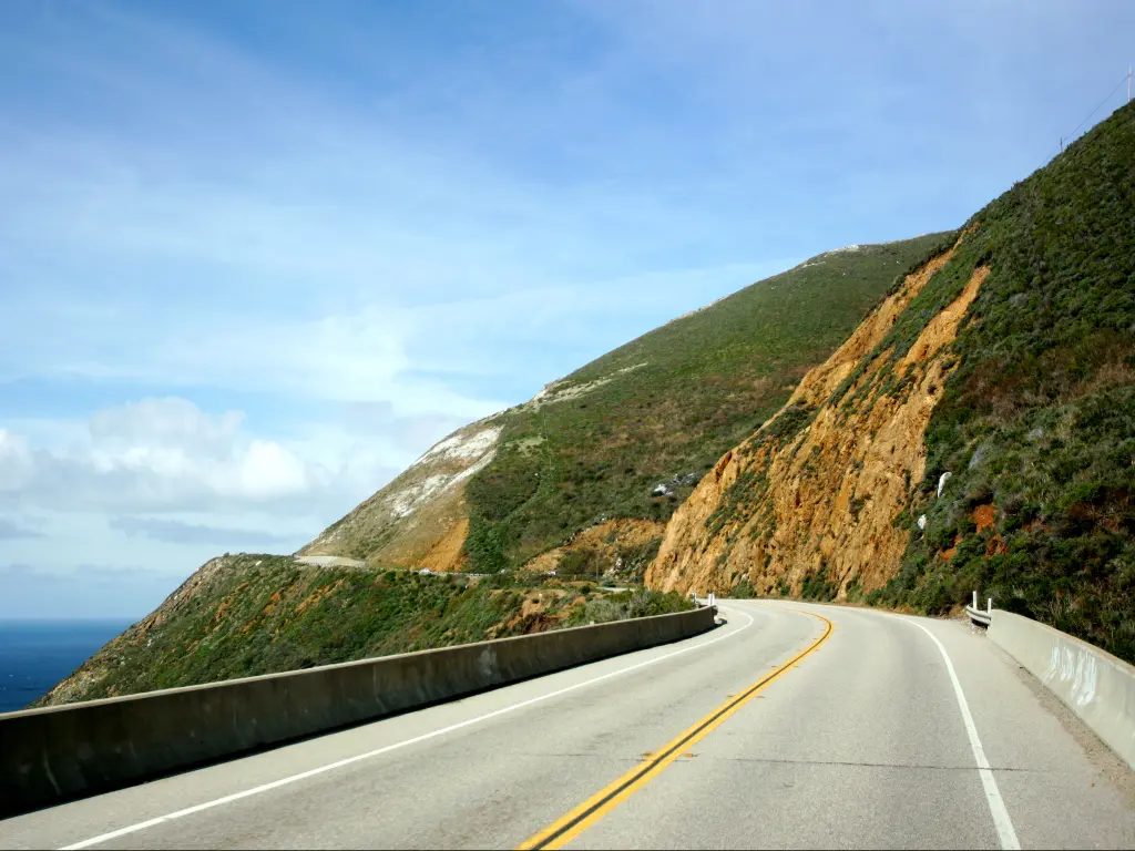 An image of the coastal highway 101, California, in a cloudy blue sky.