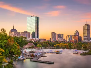Boston, Massachusetts, USA with the skyline in the background and the harbor in the foreground taken at dawn.