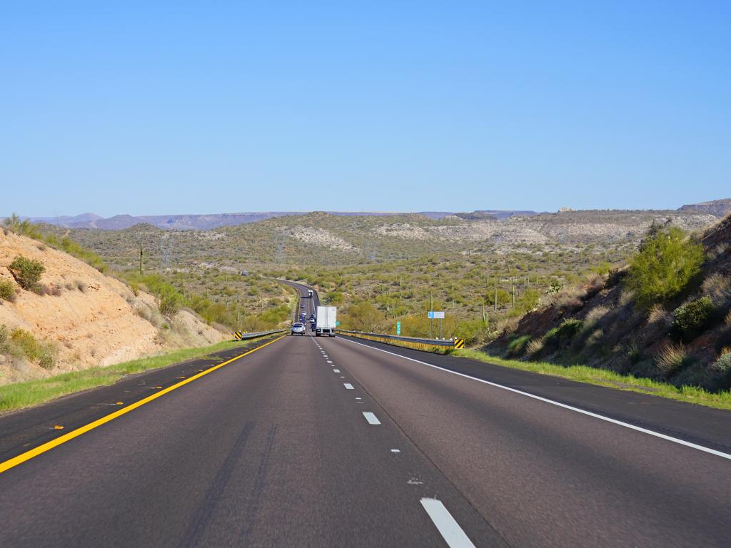 Interstate 17 at Arizona with several cars and trucks driving along the highway taking in the view of the mountains and green trees 