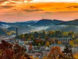 Gatlinburg cityscape during a hazy sunrise. Mountains can be seen in the background.