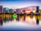 Orlando, Florida, USA taken with the downtown city skyline in the background from Eola Park at night with reflections in the water in the foreground.