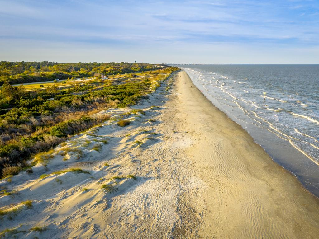 Jekyll Island, Georgia, USA with an aerial view of the beach at sunset with sand dunes. 