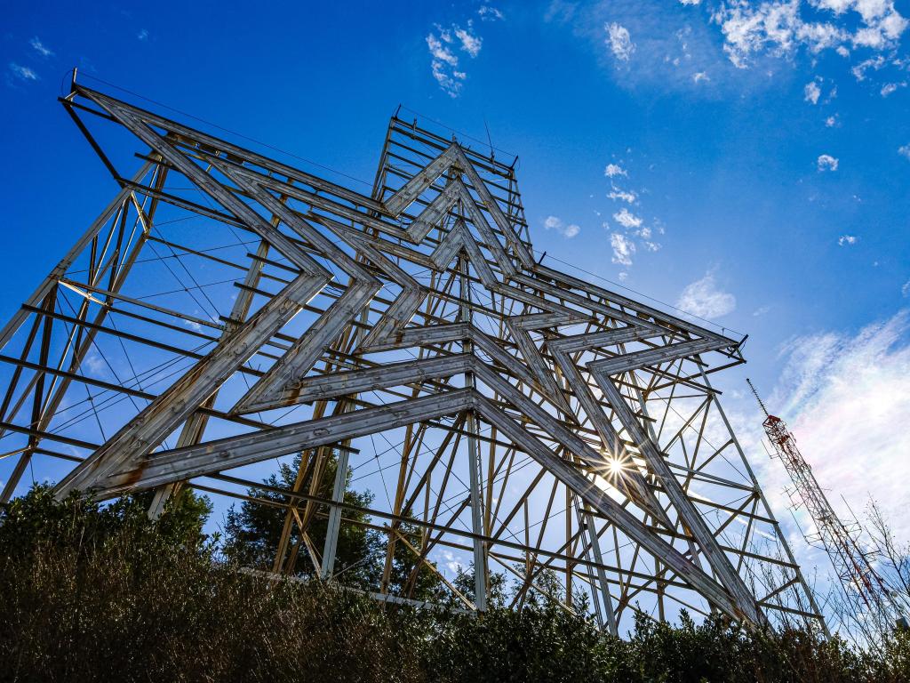 Sun coming through the slits of the famous Mill Mountain Star in Roanoke on a partially cloudy day.