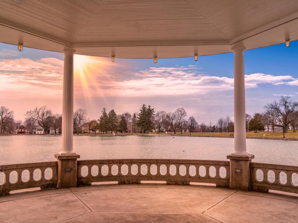 Syracuse, Upstate New York view from the gazebo overlooking the lake and trees in the distance with the sun beginning to set.