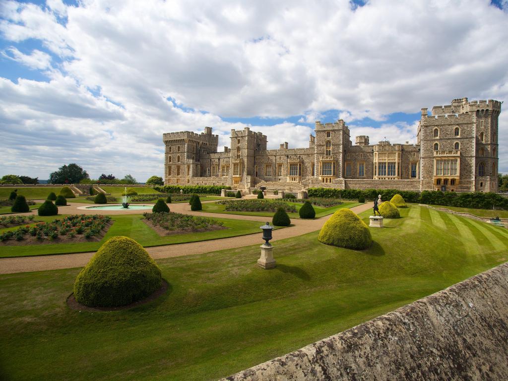 Windsor Castle, London, UK with a formal garden in the foreground and the castle in the distance.