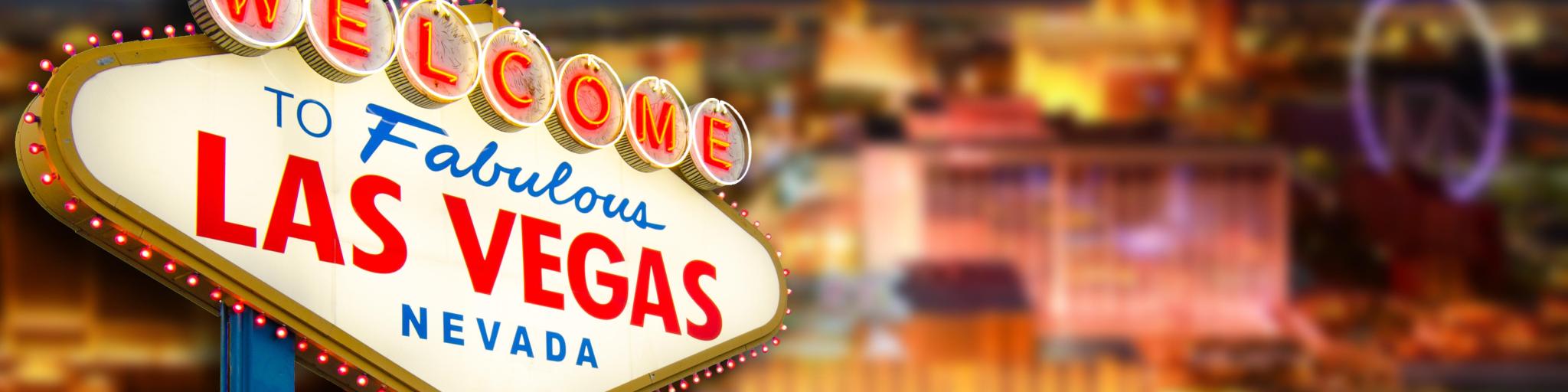"Welcome to Las Vegas" sign with the view of the city in the background at night