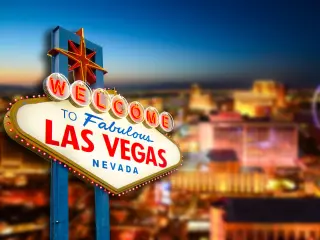 "Welcome to Las Vegas" sign with the view of the city in the background at night