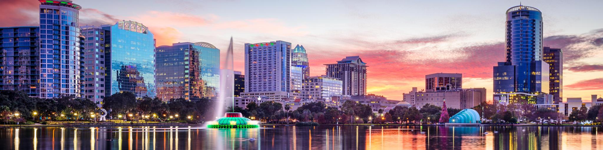Orlando, Florida with Eola Lake in the foreground and the city buildings reflecting in the background at sunset.