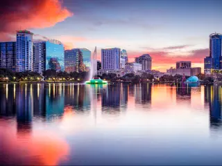 Orlando, Florida with Eola Lake in the foreground and the city buildings reflecting in the background at sunset.