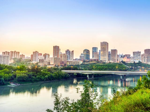Edmonton, Alberta, Canada with the city downtown in the background and the river and bridge in the foreground taken after sunset.