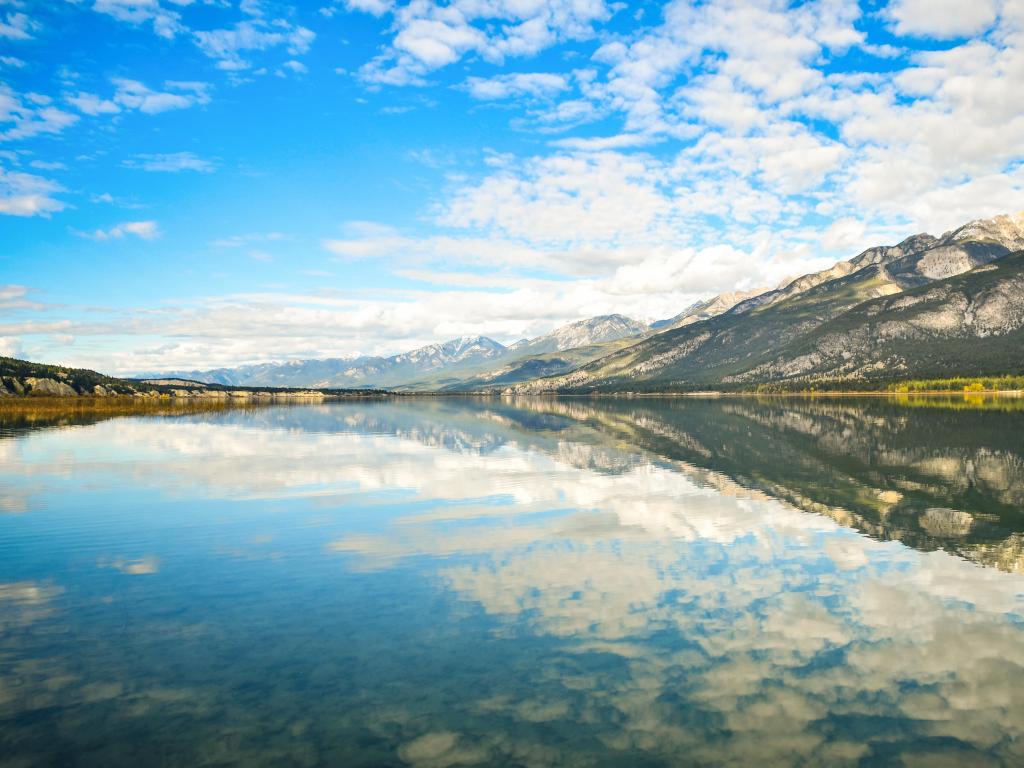 Fairmont Hot Springs, British Columbia, Canada Columbia with a lake reflection in the foreground and mountains in the background, taken on a sunny day. A classic Canadian Rockies Landscape.