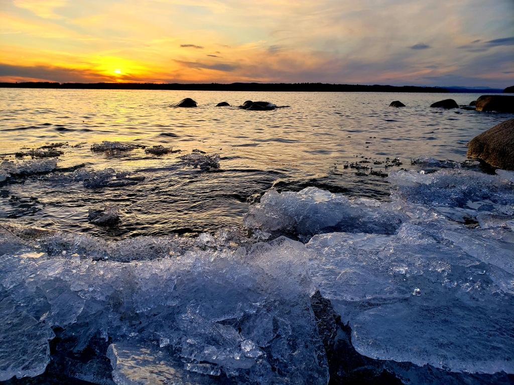 Sunset on Sebago Lake Maine with ice in the foreground