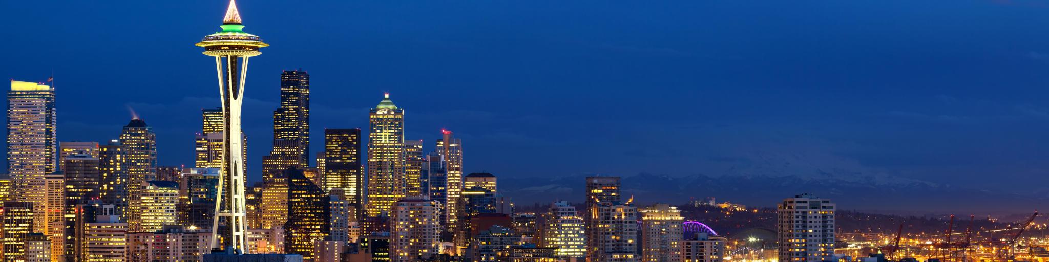 Panoramic view of Seattle at night with lights showing from high rise buildings 