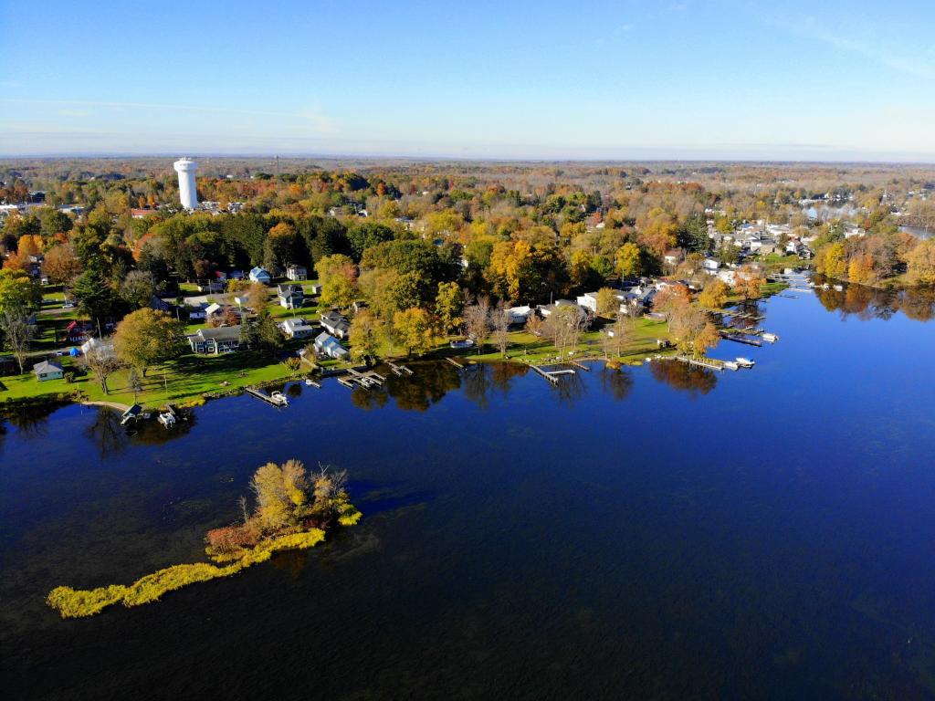The aerial view of the waterfront homes by Oneida Lake with stunning fall foliage