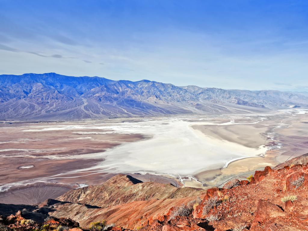 Dante's View, Death Valley National Park, California, USA with a panoramic view of salt shoreline and mountains in the distance on a sunny day.