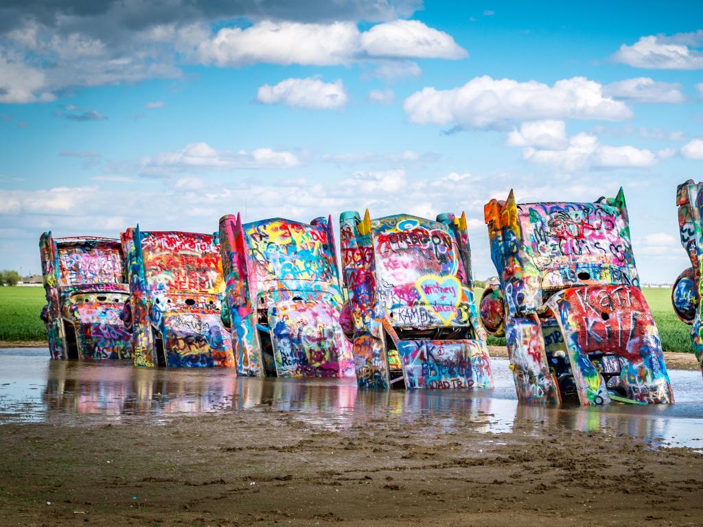 Cadillac Ranch, Amarillo, Texas, USA with a view of the cars against a blue sky.