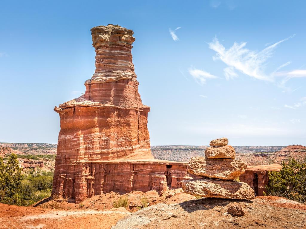 Palo Duro Canyon State Park, Texas, USA with a view of the famous Lighthouse Rock and a stone pile in the foreground on a sunny day.