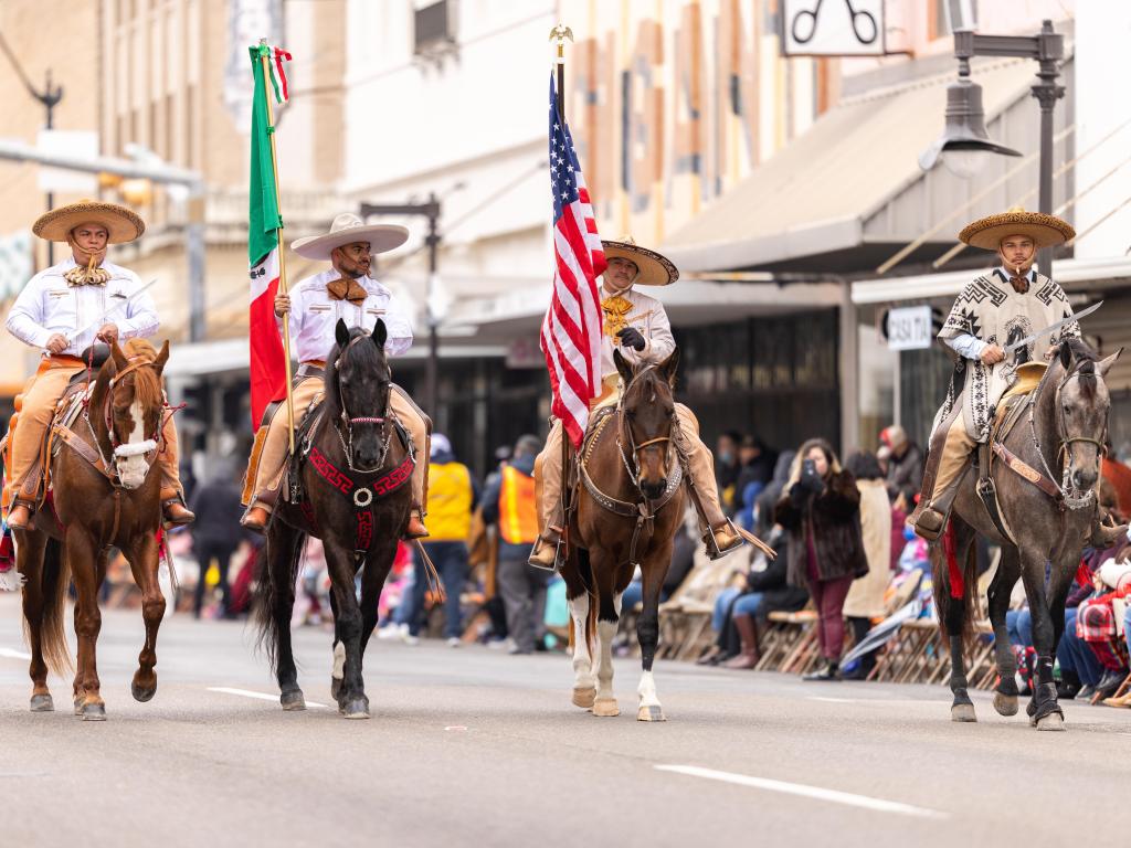 Charro Days Grand International Parade, parading Mexican and American national flags on horseback, Brownsville, Texas