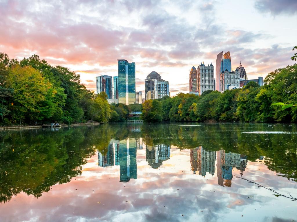 Atlanta, Georgia, USA with the city skyline in the background and reflections of midtown Atlanta in lake at Piedmont Park in the foreground taken at early evening sunset.