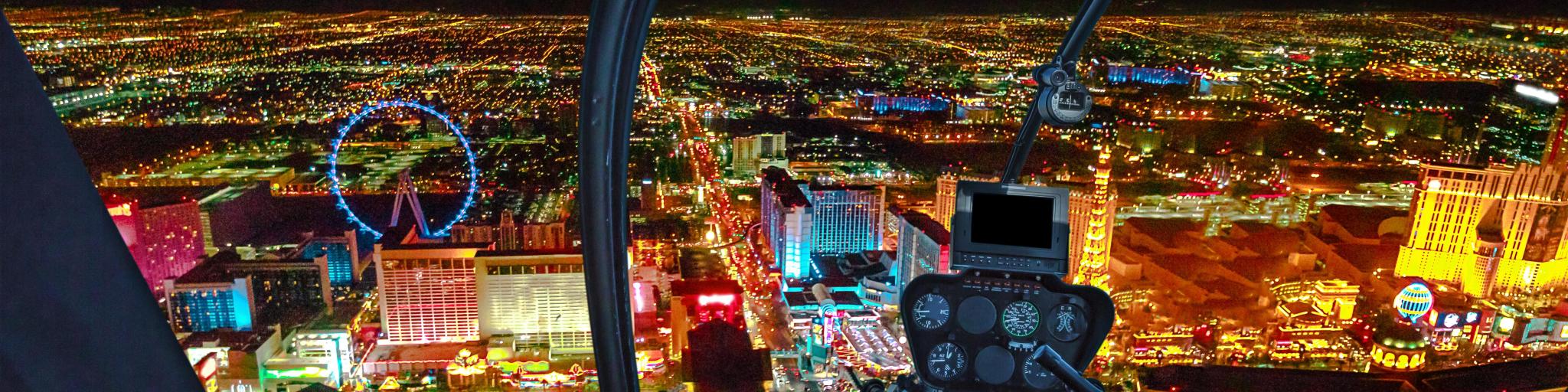 Helicopter interior on Las Vegas buildings and skyscrapers of downtown with illuminated casino hotels at night 