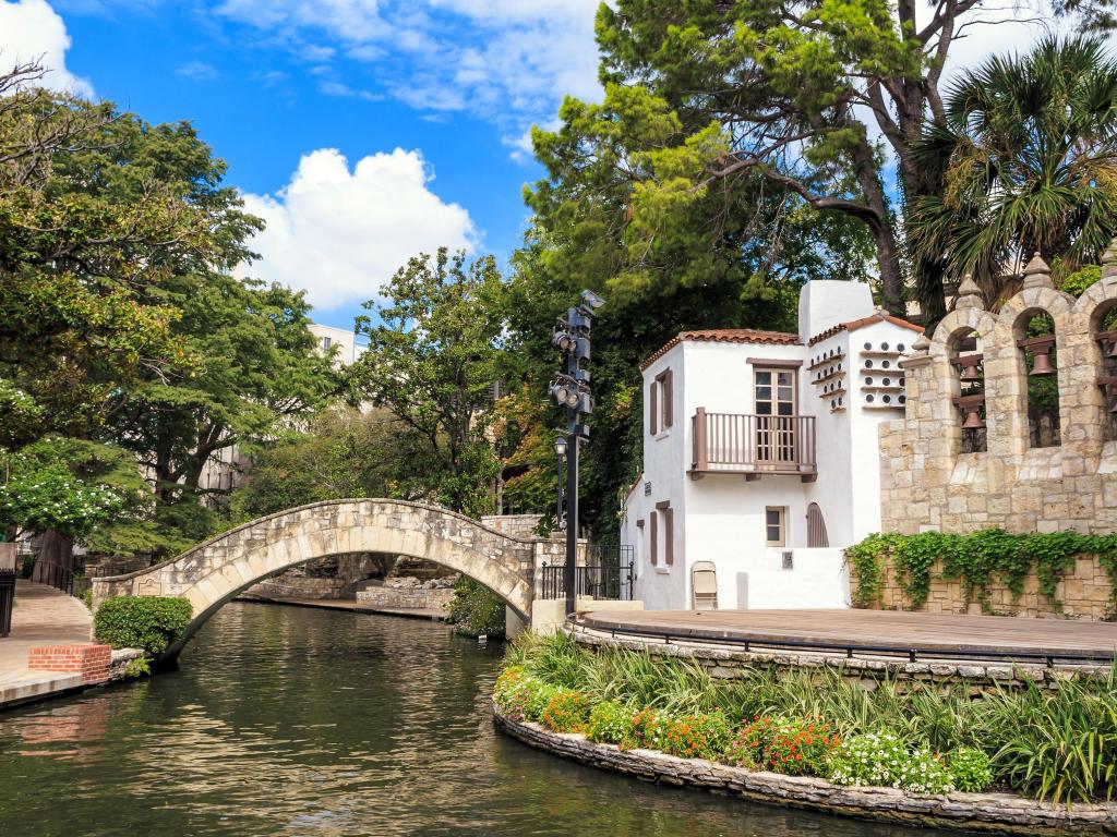 River Walk in San Antonio, Texas USA taken on a sunny day with trees and buildings on the riverbank. 