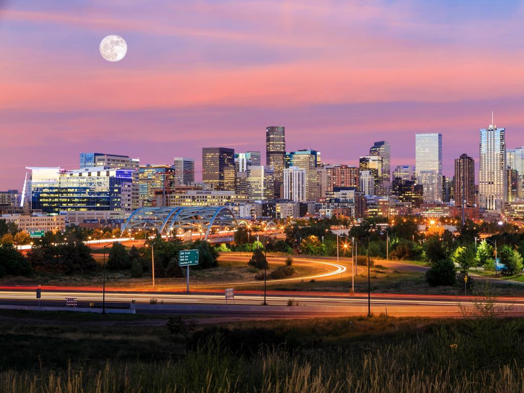 Denver, Colorado, USA taken as a panorama of Denver skyline long exposure at twilight with the moon above.