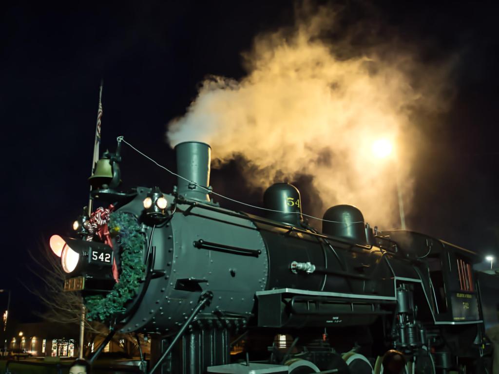 Decorated Polar Express stream train at night with steam coming from its chimney