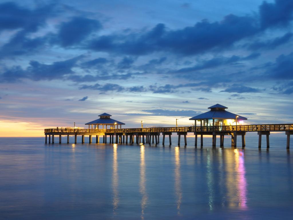 Fort Myers Pier at Sunset, Florida USA with the lights on the pier reflecting in the sea below.