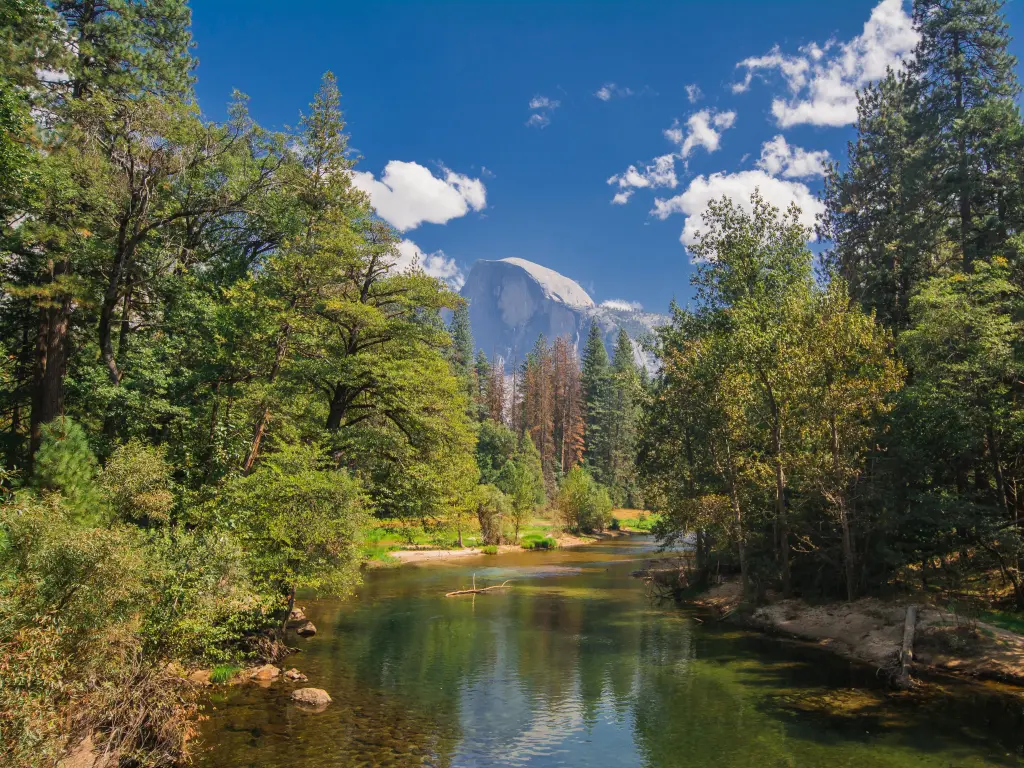 Half Dome view from on top of the bridge over Merced River on a bright day