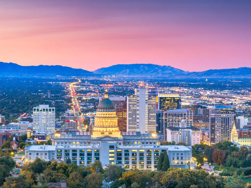 Salt Lake City, Utah, USA with the downtown city skyline at the foreground and the mountains in the distance at dusk with a beautiful red sky