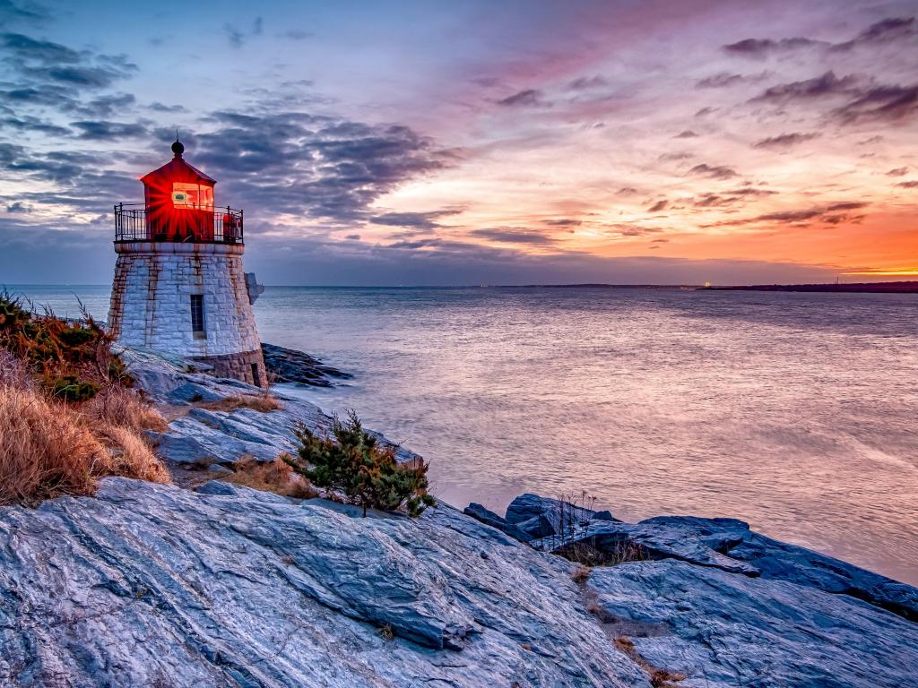 Vibrant sunset over the water with Castle Hill Lighthouse perched on the cliff's edge, Newport, Rhode Island